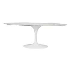 an oval dining table with white marble top and pedestal base, viewed from the front