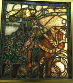 a stained glass window depicting a woman riding a horse