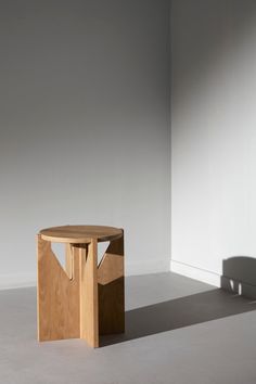 a round wooden table sitting in the middle of a room with no one around it