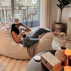 a woman sitting on a bean bag chair drinking wine