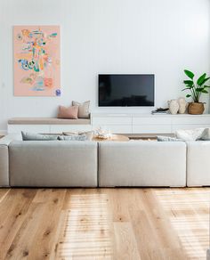 a living room filled with furniture and a flat screen tv on top of a wall