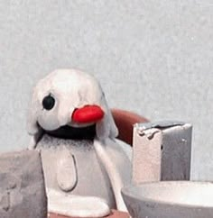 a small toy penguin sitting next to a toilet