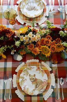 the table is set with flowers and plates