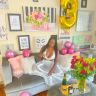 a blurry photo of a woman sitting on a couch in a room with pink and yellow decorations