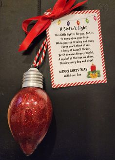 a red light bulb hanging from a christmas ornament with a poem on it