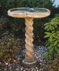 a bird bath sitting on top of a stone pedestal