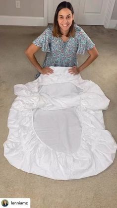 a woman standing on the floor with a white sheet