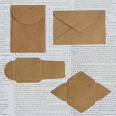 four pieces of brown paper are placed on top of an old book page with some cut outs