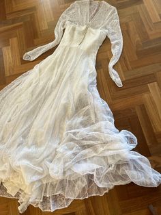 a white dress laying on top of a wooden floor