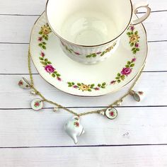 a teacup and saucer on a white table with pink flowers in the center