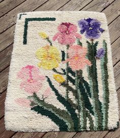 a rug with flowers painted on it sitting on a wooden floor