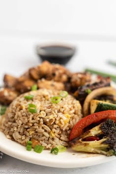 a white plate topped with rice and veggies