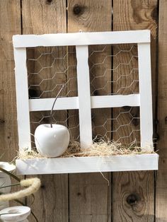 an old window is decorated with hay and a white apple