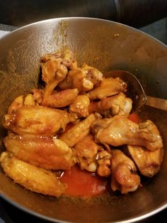 chicken wings and tomatoes in a frying pan