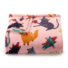 a pink blanket with cats on it is folded up and ready to be used as a bed