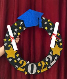 a hand holding a graduation wreath made out of construction paper and rolled up in the shape of a star