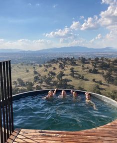 three people are in the hot tub on top of a hill