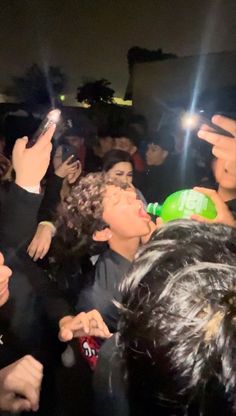 a group of people standing next to each other in front of a crowd holding cell phones