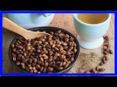 a bowl of coffee beans next to a cup of tea