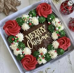 a cake decorated with red, white and green icing in a box on a table