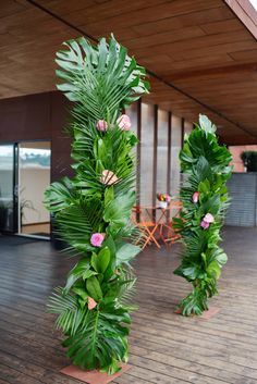 there are two tall green plants on the floor in front of an open air building