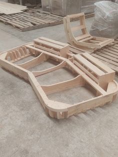 two wooden benches sitting next to each other on top of pallets in a warehouse