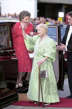 the queen waves from her car as she arrives at an event with other dignitaries and guests