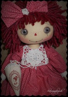 a doll with red hair wearing a pink dress