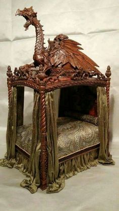 an elaborate bed with a dragon on it's head and footboard, made out of wood