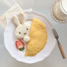 a white plate topped with a piece of cake next to a bunny shaped stuffed animal