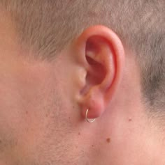 a close up of a man's ear with a ring on the middle of it