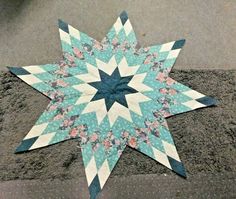 a blue and white quilted star laying on the ground