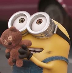 a minion holding a teddy bear in front of a car