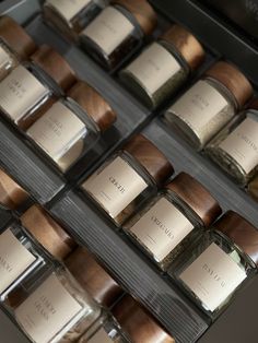 several jars with labels on them are lined up in a display case, each containing different types of spices