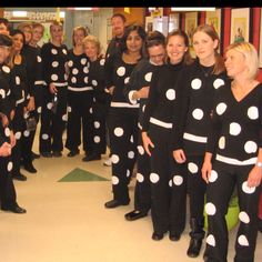 a group of women in black and white polka dot outfits standing next to each other