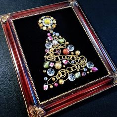 a decorative christmas tree made out of glass beads and gold chains on a black background