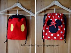 there are two bags hanging on the clothes rack with mickey and minnie mouse heads in them