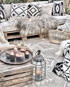 a living room filled with lots of pillows and candles on top of a wooden table