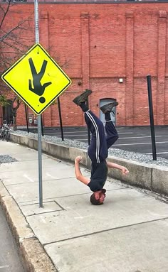 a man doing a handstand on the sidewalk next to a sign that says, when the sign god gave you doesn't seem to make sense but you still follow