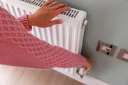 a woman is holding the radiator in her hand and pressing buttons on it