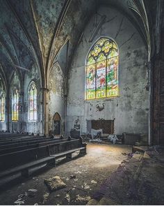 an old church with stained glass windows and pews in the foreground is empty