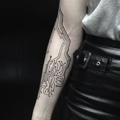 a woman's arm with a circuit board tattoo on it