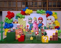 a nintendo themed birthday party with balloons, decorations and mario bros characters on the wall