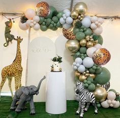 an elephant, giraffe, zebra and balloon arch for a baby shower