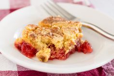 a piece of pie on a white plate with a fork and checkered table cloth