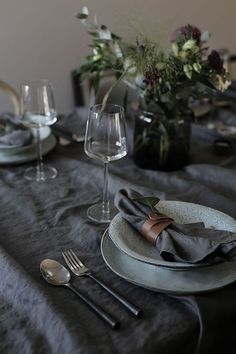 the table is set with silverware and flowers