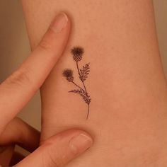 a woman's foot with a small flower tattoo on the side of her ankle