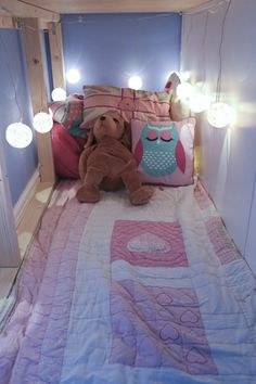 a teddy bear sitting on top of a bed in a room with blue walls and lights