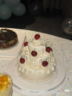 a table with two cakes on it and balloons in the background