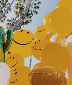 yellow balloons with smiley faces and palm trees in the background